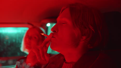 Young-Couple-Smoking-in-Car-with-Red-Light